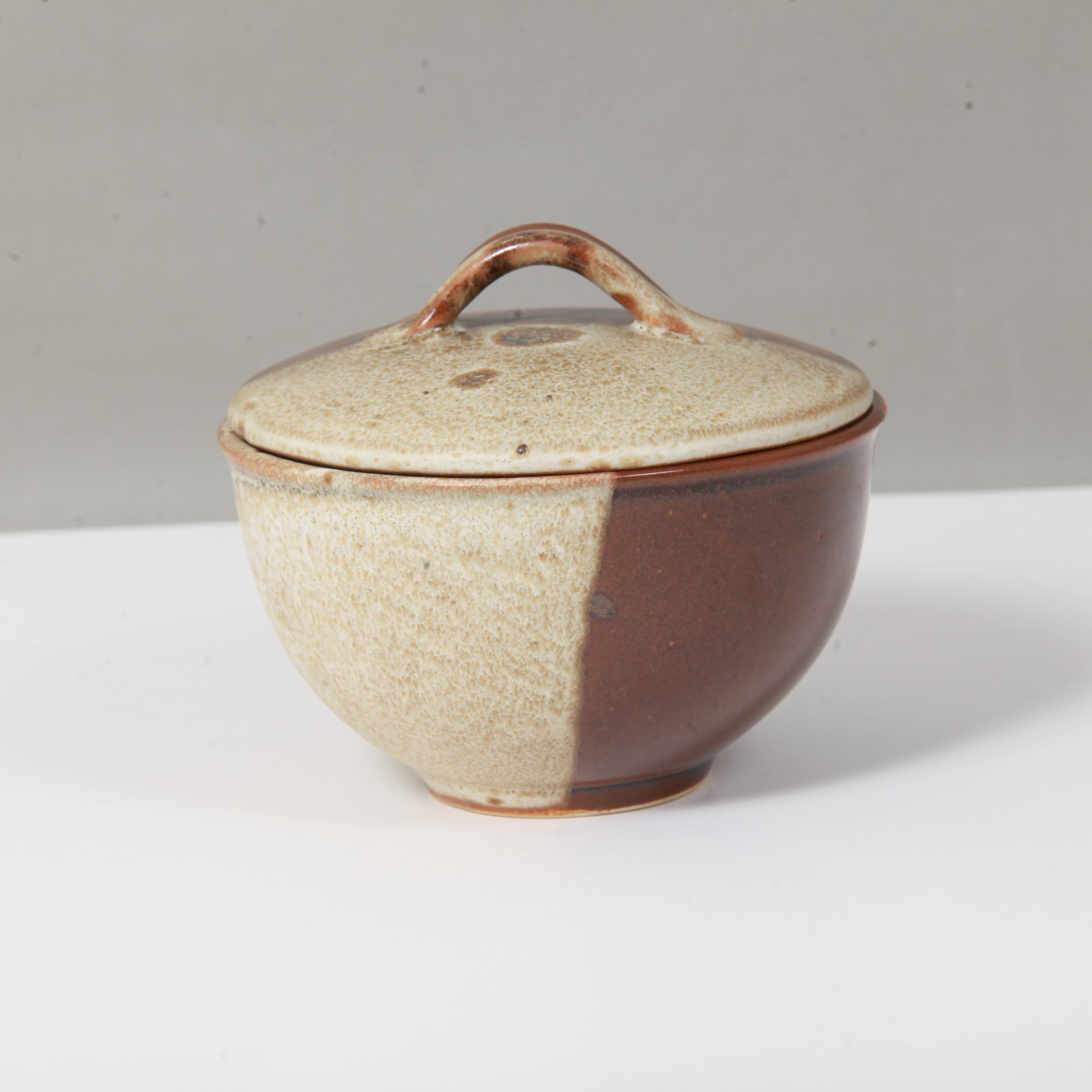 Ceramic pot with a lid on a white surface